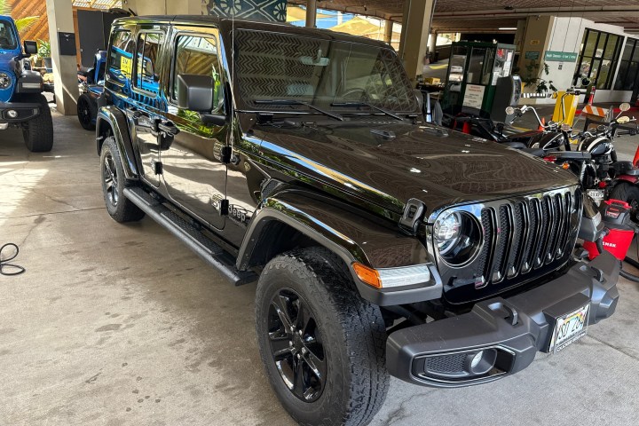 A black SUV parked indoors on a concrete floor.